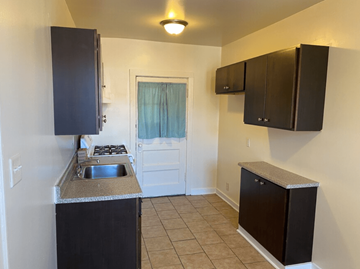 Chicago apartment for rent - A kitchen with black cabinets and a white door.