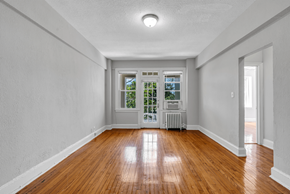 Washington apartment for rent - an empty living room with wood floors and a door to a balcony