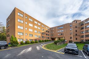 Maryland apartment for rent - A parking lot in front of a brick apartment building.