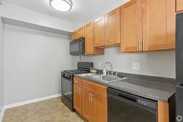Washington apartment for rent - A kitchen with wooden cabinets and black appliances.