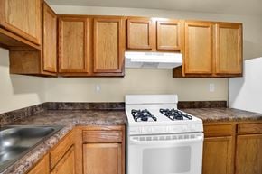 Washington apartment for rent - A white gas stove in a kitchen with wooden cabinets.