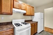 Washington apartment for rent - A white stove is in a kitchen with wooden cabinets.