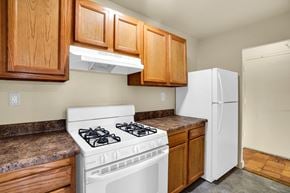 Washington apartment for rent - A white stove is in a kitchen with wooden cabinets.
