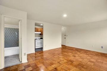 Washington apartment for rent - A kitchen with a white dishwasher and a window with a blue tiled wall.