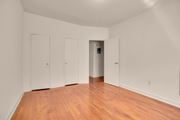 Hyattsville apartment for rent - A room with wood floors and white walls with three doors and one open.