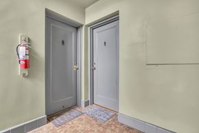 Silver Spring apartment for rent - A hallway with two doors and a fire extinguisher on the wall.