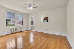 Washington apartment for rent - A room with wooden floors and a ceiling fan.