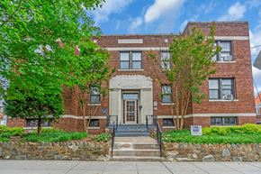 Washington apartment for rent - A red brick building with a stone wall in front.