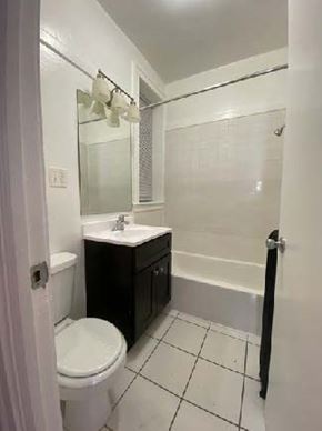 Chicago apartment for rent - A white toilet sits next to a sink in a small bathroom.
