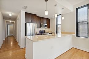 Washington apartment for rent - A kitchen with a white island and wooden cabinets.