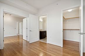 Washington apartment for rent - A room with white walls and wooden floors with a doorway leading to another room.