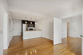 Washington apartment for rent - A spacious room with wooden floors and white walls.