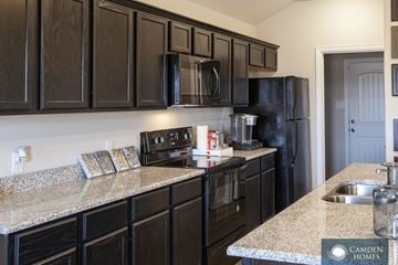 Dallas apartment for rent - A kitchen with black cabinets and granite countertops.