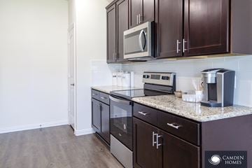 Dallas apartment for rent - A kitchen with dark brown cabinets and stainless steel appliances.
