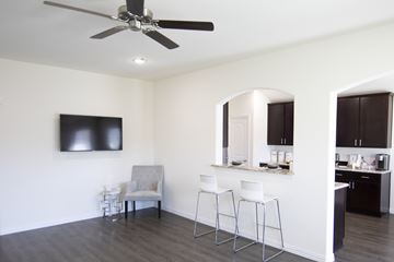 Dallas apartment for rent - A living room with a grey couch and a television on the wall.