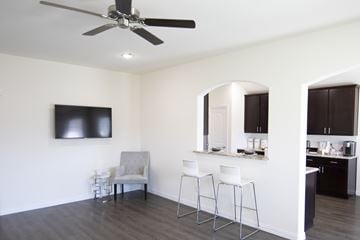 Dallas apartment for rent - A living room with a grey couch and a television on the wall.
