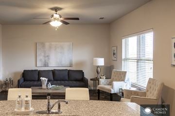 Red Oak apartment for rent - A living room with a grey couch, a table with a lamp and a painting on the wall.