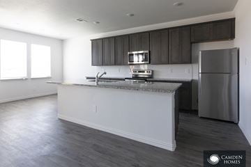 Dallas apartment for rent - A kitchen with a stainless steel refrigerator and a countertop with a sink.