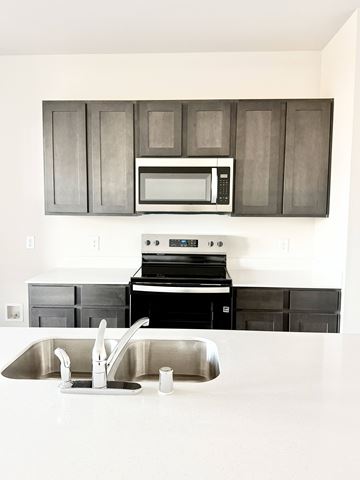 Princeton apartment for rent - A modern kitchen with a stainless steel sink and black cabinets.