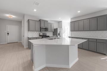 Red Oak apartment for rent - A modern kitchen with a white island and wooden floors.