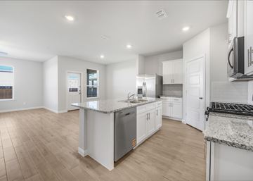Farmersville apartment for rent - A spacious kitchen with white cabinets and a granite countertop.