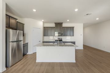 Anna apartment for rent - A modern kitchen with a stainless steel refrigerator and wooden flooring.
