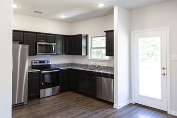 Athens apartment for rent - A kitchen with black cabinets and stainless steel appliances.