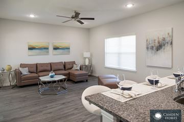 Red Oak apartment for rent - A living room with a brown couch, a coffee table, and a painting on the wall.
