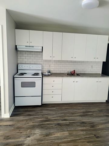 Dunnville apartment for rent - A white kitchen with a stove and cabinets.