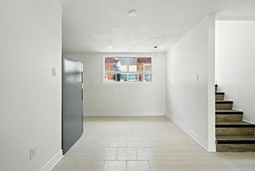Lindsay apartment for rent - A kitchen with a refrigerator and a window with a view of a city.