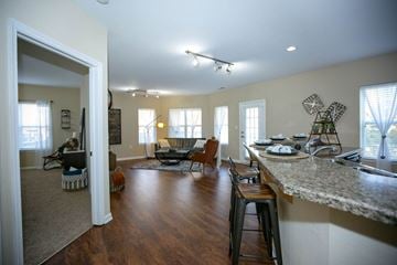 Virginia Beach apartment for rent - A kitchen with a bar and a living room with a couch and chairs.