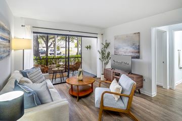Miami apartment for rent - A living room with a sofa, a chair, a coffee table, and a painting on the wall.