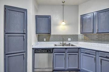 Duncanville apartment for rent - A kitchen with blue cabinets and a white counter.