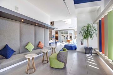 Long Beach apartment for rent - A modern living room with a grey sofa, a green chair and a blue ottoman.