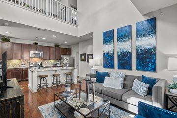 Houston apartment for rent - A modern living room with a grey couch and a bar area.