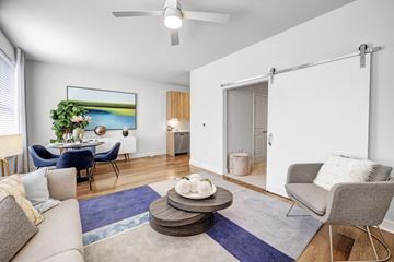 Largo apartment for rent - A living room with a grey couch, a blue chair, a grey armchair, a coffee table, and a painting on the wall.