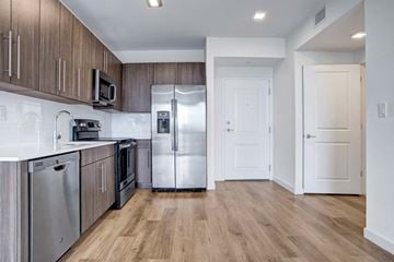 Miami apartment for rent - A kitchen with wooden cabinets and stainless steel appliances.