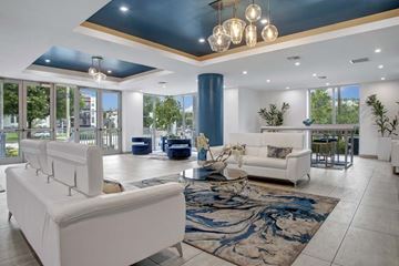 Miami apartment for rent - A modern living room with a white sofa and a blue rug.
