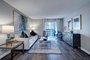 Denver apartment for rent - A living room with a white couch, a coffee table, and a painting on the wall.
