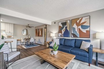 Phoenix apartment for rent - A living room with a blue couch and a wooden coffee table.