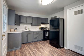 Columbus apartment for rent - A kitchen with dark wood cabinets and a black refrigerator.