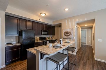 Canal Winchester apartment for rent - A kitchen with a black refrigerator and brown cabinets.
