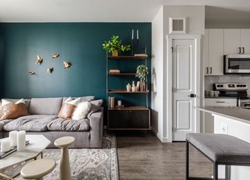 Denver apartment for rent - A living room with a grey couch and a grey ottoman.