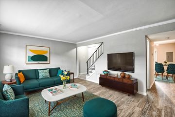 Virgnia Beach apartment for rent - A living room with a green couch, a white coffee table, and a painting on the wall.