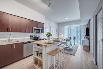 West Palm Beach apartment for rent - A modern kitchen with brown cabinets and a white island.