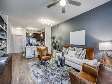 Katy apartment for rent - A modern living room with a brown leather chair and a glass coffee table.