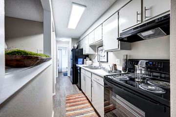 Broomfield apartment for rent - A kitchen with black appliances and white cabinets.
