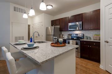 Bala Cynwyd apartment for rent - A kitchen with a granite countertop and white chairs.