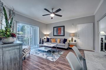 Dallas apartment for rent - A living room with a grey sofa and a wooden cabinet.