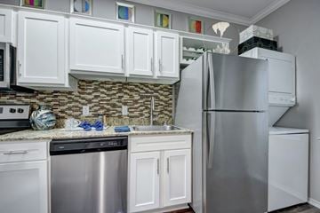Dallas apartment for rent - A kitchen with white cabinets and a stainless steel refrigerator.